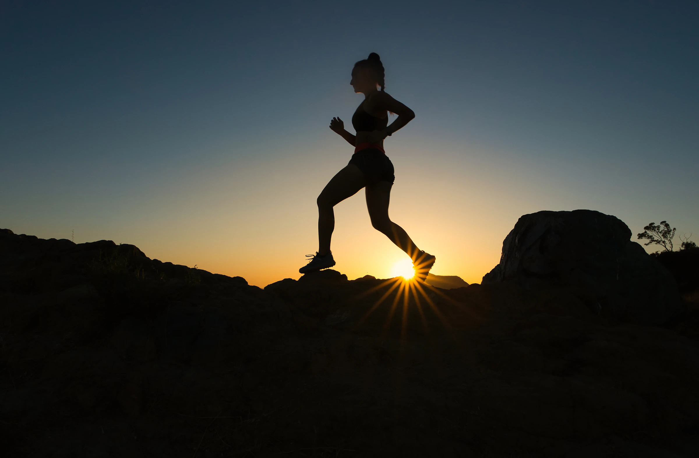 Runner silhouetted against a low sun